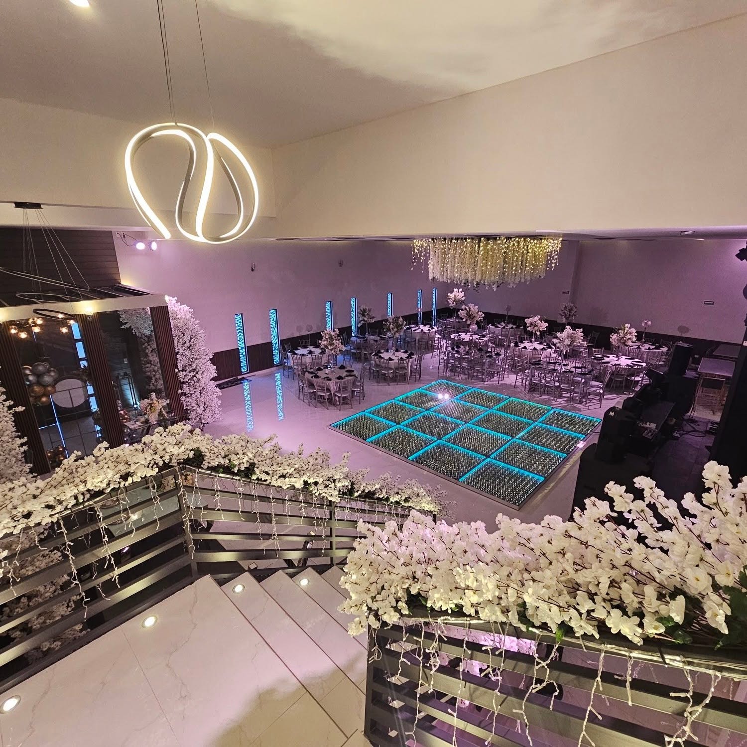 Vista aérea del salón principal con candil floral y pista LED
